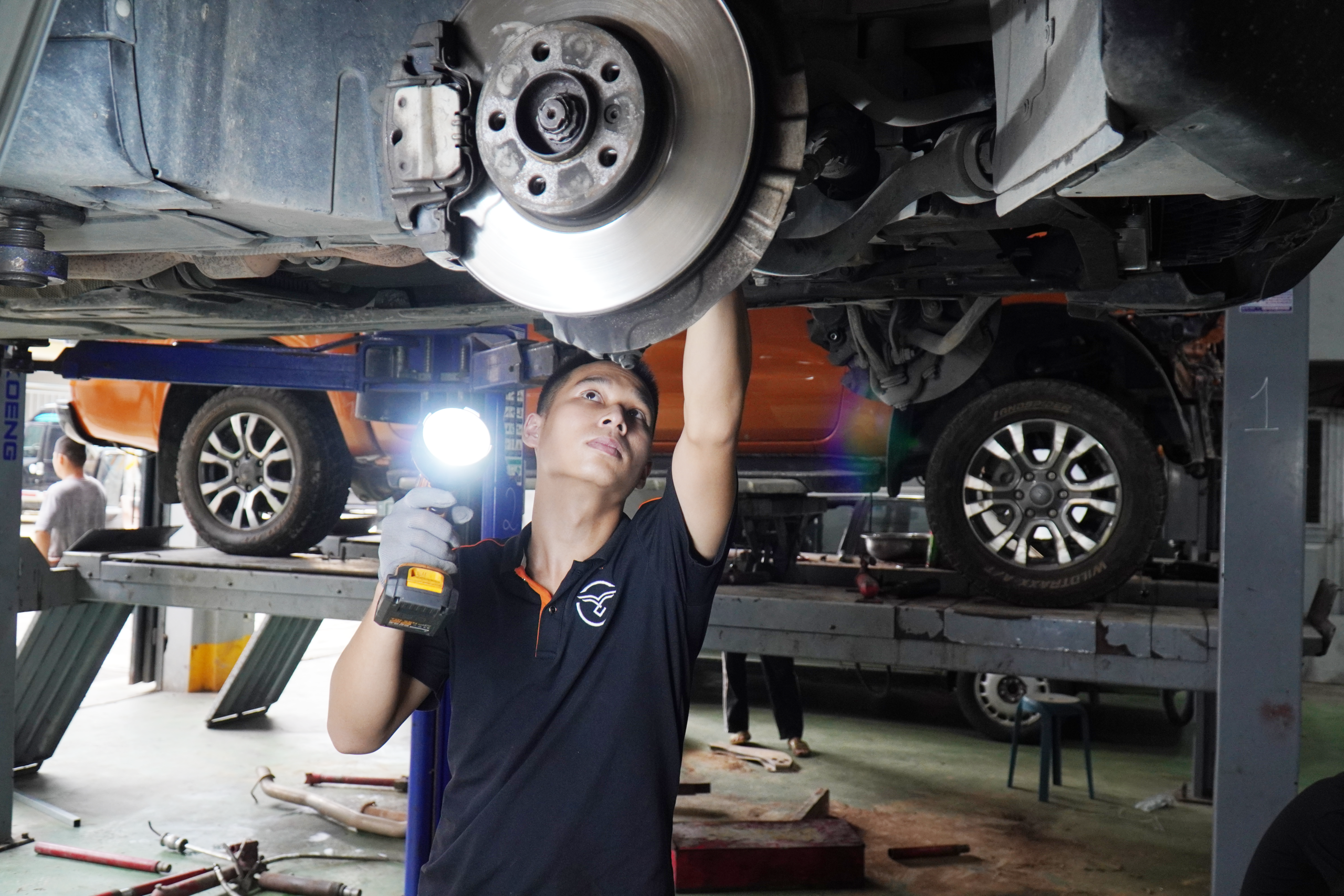 Kỹ thuật viên kiểm tra hệ thống gầm, phanh trên cầu nâng